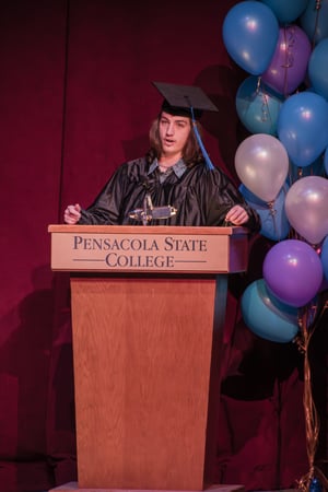 Man stands at graduation podium