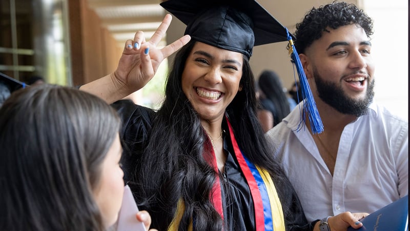 LAA Graduate Sofia Criollo smiles and flashes a peace sign at graduation