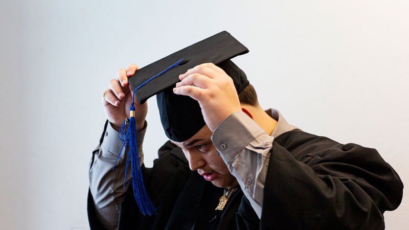 Graduate adjusts his cap