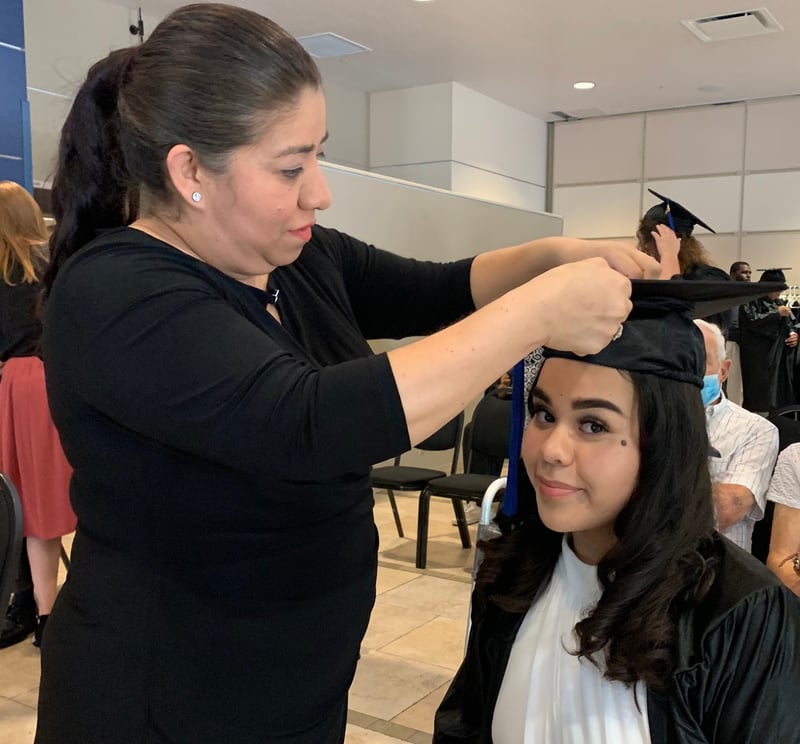 Mother fixes cap for her daughter at graduation ceremony