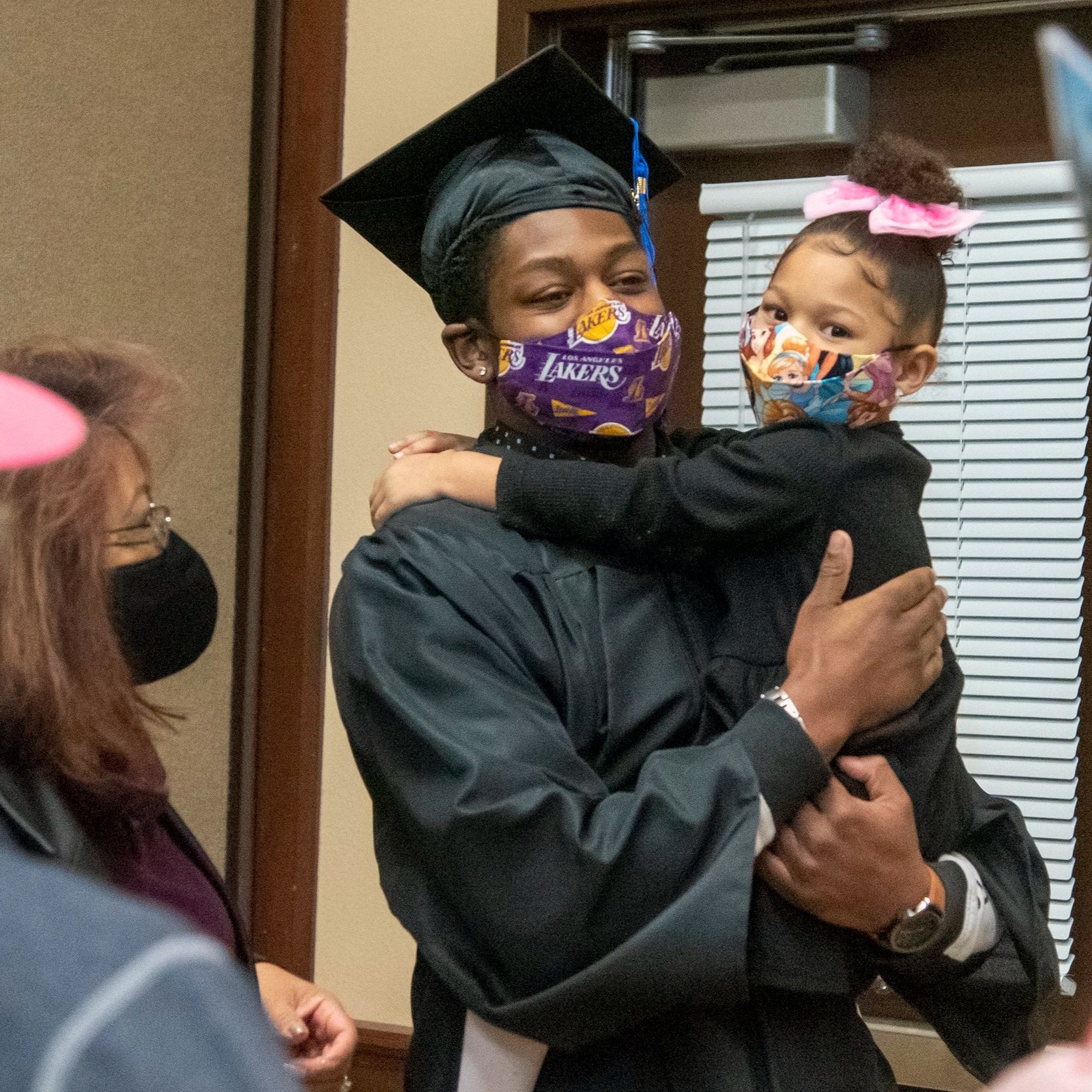 VaShon Evans-Barnwell in cap and gown with daughter