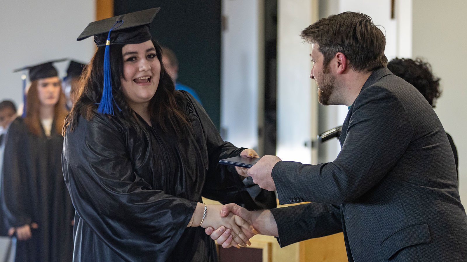 Selena Farlow shakes WAA Director's hand while receiving diploma
