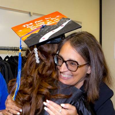 woman hugs graduate