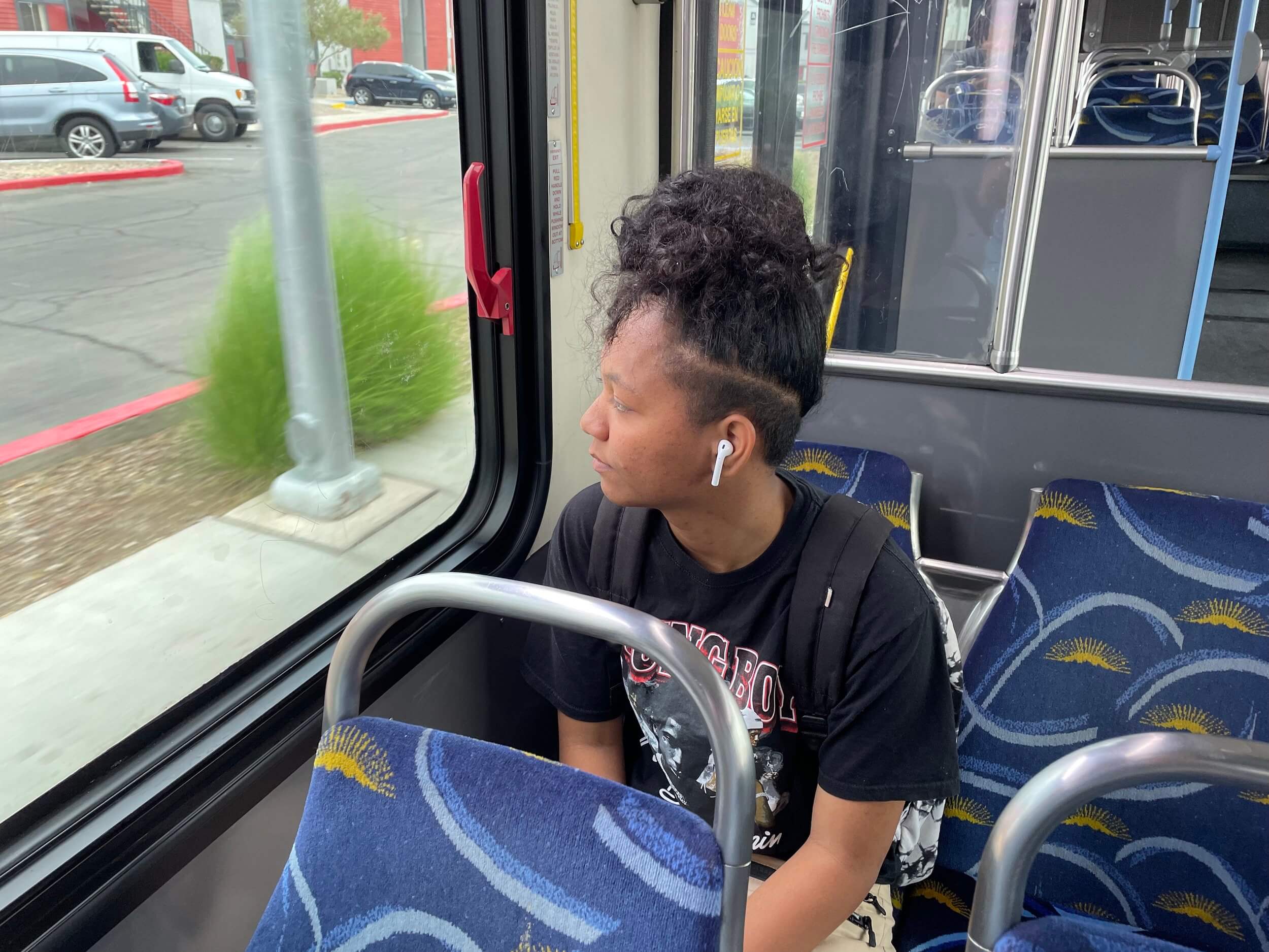 A student sits on a bus looking out the window